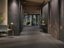 Wnętrze korytarza hotelowego z czarnymi płytkami ścienno-podłogowymi imitującymi marmur Porcelanosa Liem Dark Nature