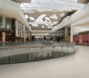 Aranżacja wnętrza galerii handlowej z wykorzystaniem płytek Marazzi Market New Sand Ivory 60x60 cm na podłodze, szklane ściany i metalowe elementy konstrukcyjne stanowią stylowe akcenty w jasnym wnętrzu