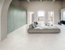 Aranżacja salonu z wykorzystaniem płytek Marazzi Mystone Berici Bianco na podłodze, sofa i minimalistyczny wystrój stanowią eleganckie tło dla nowoczesnego designu