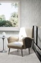 Minimalistyczna przestrzeń z podłogą i ścianą pokrytą jasnymi płytkami Marazzi Naturalia Bianco, które nadają wnętrzu nowoczesny i elegancki wygląd, w kadrze znajduje się również designerski fotel w odcieniach bieli i beżu oraz fragment okna