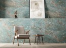 Pomieszczenie z krzesłem oraz drewnianym stolikiem oraz ozdobami na ścianie, która jest wyłożona płytkami Prime Ceramics Amazonit 60x120 w zielonym odcieniu