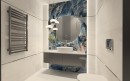 Nowoczesna łazienka z szarym grzejnikiem powieszonym na ścianie z kremowymi płytkami a na środku kontrastująca niebieska płytka Prime Ceramics Onyx Blue High Glossy 60x120 na której wisi duże okrągłe lustro oraz szafka z umywalką