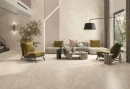 Nowoczesny salon z jasną kanapą oraz krzesłami w kolorze oliwkowym, duże panoramiczne okno które daje dużo światła. Na podłodze położone są płytki Cicogres Fame Ivory Pulido 60x120