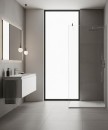 Jasna łazienka z kwadratowymi, szarymi płytkami Marazzi SistemS Cenere 60x60 MQYL na ścianach i podłodze, z wiszącą białą szafką umywalkową, podświetlanym lustrem i minimalistyczną, szklaną ścianką prysznicową typu walk-in
