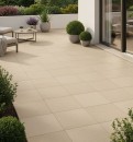 Nowoczesny taras z kwadratowymi, beżowymi płytkami tarasowymi Marazzi Slow20 Calce 80x80 cm MGR9, z wygodnymi meblami wypoczynkowymi i bujną zielenią w donicach