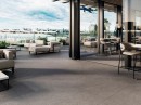 Restauracja z tarasem widokowym i z płytkami podłogowymi imitującymi kamień, w kolorze szarym Porcelanosa Tourmalet Granito