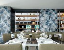 Salon restauracyjny z multikolorowymi płytkami dekoracyjnymi z roślinnym motywem Marazzi White Deco Decoro Jungle Touch Set 60x180 cm MF9C na ścianach, tworzącymi tropikalną i stylową atmosferę