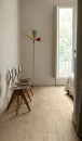 Pokój mieszkalny z trzema designerskimi krzesłami, kolorową lampą i podłogą z długich, jasnych płytek drewnopodobnych Marazzi Vivo Grano 20x150 cm MN91, które dodają elegancji przestrzeni
