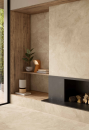 Salon z ozdobnym kominkiem oraz beżowymi płytkami ścienno-podłogowymi imitującymi kamień Caesar Haven Oat