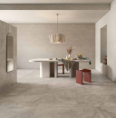 Nowoczesne wnętrze z oryginalnym długim białym stołem oraz  szarymi płytkami ścienno-podłogowymi imitującymi kamień Caesar Haven Earth