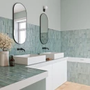 Zielona gresowa płytka dekoracyjna Gayafores Artis Green 32x62,5 na ścianach łazienki. Kontrastujące elementy w czarnym kolorze takie jak rama lustra i podtynkowe baterie umywalkowe