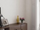 W pomieszczeniu znajduje się drewniana ciemna szafka na niej są ozdoby typu obraz, lampa oraz kwiaty. Na ścianie położone są płytki Cifre Granite White Mate Rect. 30x90
