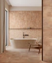 Dekoracyjne, gresowe płytki podłogowe w beżowym kolorze Gayafores Deco Saona Chiaro 33,15x33,15 na ścianie łazienki. Kremowa wanna wolnostojąca oraz czarna podtynkowa armatura łazienkowa.