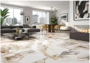 Płytka gresowa, podłogowa imitująca biały marmur, wykończenie powierzchni w połysku. Geotiles Valeria Oro Rect. 60x120, położona na podłodze w dużym salonie z szarym wypoczynkiem, obrazami oraz oknami z widokiem na centrum