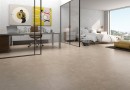 Płyta gresowa, podłogowa w kolorze beżowym, wykończenie powierzchni matowe, Geotiles Sena Taupe Natural 60,8x60,8 położona na podłodze w sypialni z dużym łóżkiem oraz oknem z widokiem na miasto, oraz w gabinecie z biurkiem
