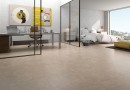 Płyta gresowa, podłogowa w kolorze beżowym, wykończenie powierzchni matowe, Geotiles Sena Marfil Natural 60,8x60,8 położona na podłodze w sypialni z dużym łóżkiem oraz oknem z widokiem na miasto, oraz w gabinecie z biurkiem