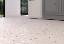 Gresowa płytka imitująca beżowe lastryko z kolorowymi  kamyczkami Pamesa Doria Sabbia 60x120 na podłodze kuchni skomponowane z szarymi szafkami.