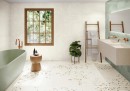 Gresowa płytka podłogowa imitująca lastryko Peronda Harmony Awen White Decor Natural 90x90  na podłodze łazienki z płytkami w zielonym kolorze na ścianie oraz zieloną wanną wolnostojącą