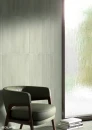 Gresowa płytka cegiełka w zielonym kolorze Equipe Stonella Leaf 7,5x60  na ścianie i podłodze salonu z dopasowanym zielonym fotelem o ciemno brązowych nogach