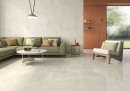 Płytka gresowa, podłogowa w kolorze beżowym, wykończenie powierzchni w połysku, Geotiles Cremo Natural Pulido Rect. 60x120 położona na podłodze w pokoju gdzie znajduje się zielona z białym stolikiem kawowym oraz wisząca lampa