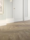 Korytarz z płytkami podłogowymi drewnopodobnymi ułożonymi w jodełkę Porcelanosa Smart Tanzania Natural