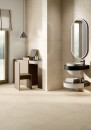 Gresowa podłogowa płytka imitująca lastryko Fioranese I Ciottoli Sabbia Beige Esterno 60,4x120,8 LM622ER na podłodze nowoczesnej łazienki z półokrągłym czarnym podwieszanym blatem wpuszczaną umywalką oraz okrągłym lustrem na ścianie