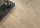 Płytka gresowa, podłogowa w kolorze brązowym imitująca drewno, wykończenie powierzchni matowe, Cerrad Sentimental Wood Beige 19,3x120,2, położona na podłodze gdzie znajduje się ciemna półka