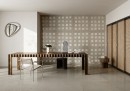 Gresowa podłogowa płytka imitująca beton Fioranese The Blend Concrete Clay Levigato-Matt 60,4x120,8 GC620LR na podłodze biura w zestawieniu z drewnianym stole, czarnym krzesłem i dekoracyjnymi płytkami Glass z tej samej serii