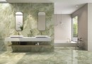 Płytka gresowa, podłogowa imitująca kamień w kolorze zielonym, wykończenie powierzchni w połysku, Pamesa Lux Noor Apple Polished 60x120 zielone płytki kamienne położona na podłodze i ścianie w łazience gdzie znajduje się duża wanna oraz dwie umywalki