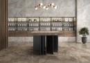 Płytka gresowa, podłogowa imitująca kamień w kolorze brązowym, wykończenie powierzchni w połysku, Pamesa Lux Noor Nut Polished 60x120 położona na podłodze w pomieszczeniu gdzie znajduje się stół na środku, wisząca lampa oraz półki z kosmetykami