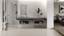 Płytka gresowa, podłogowa imitująca kamień w kolorze beżowym, wykończenie powierzchni w połysku, Pamesa Belvedere Ivory Polished 60x120 położona na podłodze w łazience gdzie znajduje się prysznic, stolik na kosmetyki oraz umywalka i wiszące lustro