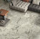 Elegancki salon w stylu glamour z płytkami ścienno-podłogowymi imitującymi marmur Caesar Anima Wonder Glacier, modułową sofą i nowoczesnym stolikiem kawowym