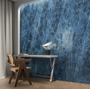 Kącik z biurkiem, krzesłem, drewnianą podłogą ułożoną w jodełkę oraz niebieskimi płytkami ściennymi imitujacymi marmur Caesar Anima Wonder Starlit