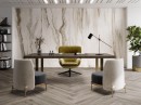 Płytka gresowa, podłogowa imitująca kamień w beżowym kolorze, wykończenie powierzchni w połysku, Pamesa Nebula Almond Polished 60x120 położona na ścianie w gabinecie gdzie znajdują fotele, drewniane biurko oraz półki z książkami