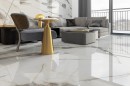 Płytka gresowa, podłogowa imitująca marmur w beżowym kolorze, wykończenie powierzchni w połysku, Pamesa Pietra Di Marmi Polished 60x60 położona na podłodze oraz ścianie w pokoju gdzie znajduje się szary wypoczynek ze stolikiem kawowym i drzwi balkonowe