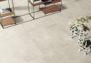 Wnętrze z jasnymi płytkami podłogowymi imitującymi beton  Caesar I.MAT Ratio