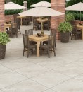 Płyta gresowa, tarasowa imitująca kamień w szarym kolorze, wykończenie powierzchni matowe, antypoślizgowe, Netto Ceramika Bochum Taupe Matt 60x60 - 20mm położona na tarasie gdzie znajdują się stoliki wraz z krzesełkami