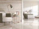 Płytka ścienna imitująca kamień, wykończenie powierzchni satynowe strukturalne, Pamesa Rlv. Verona Ivory Satin 60x120 położona na ścianie w pokoju gdzie znajduje się fotel, lampka oraz przejście do sypialni