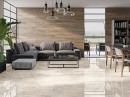 Płytka gresowa, podłogowa imitująca kamień w kolorze beżowym, wykończenie powierzchni w połysku, Pamesa Wells Cream Polished 120x120 położona na podłodze w salonie gdzie znajduje sie szary wypoczynek, okna oraz drewniane ściany