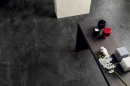 Wnętrze z czarną płytką podłogową imitującą kamień w stylu industrialnym Caesar Inner Cliff