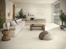Płytka gresowa, podłogowa imitująca kamień w kolorze beżowym, wykończenie powierzchni matowe, Baldocer Venice Beige Natural Rect. 60x120 położona na ścianie oraz podłodze w salonie gdzie znajduje się wypoczynek, drewniany stolik oraz duże okno