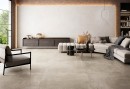 Płytka gresowa, podłogowa imitująca kamień w beżowym kolorze, wykończenie powierzchni matowe, Pamesa Montpellier Bone Matt 60x120 położone na podłodze w salonie gdzie znajduje się jasny wypoczynek, stolik kawowy oraz drewniana szafka