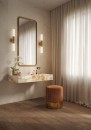 Elegancka strefa toaletki w nowoczesnym wnętrzu, gdzie podłogę zdobią ciemnobrązowe płytki gresowe Marazzi Nobilis Noce Classico 20x120 cm MQ91 o wyglądzie naturalnego drewna, na ścianie wisi pionowe lustro w złotej ramie