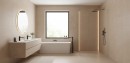 Nowoczesna łazienka utrzymana w minimalistycznym stylu, w której zastosowano wielkoformatowe płytki Marazzi Resin Beige 60x120 cm kod MQPJ, beżowe płytki o matowym wykończeniu betonu pokrywają zarówno podłogę, jak i ściany, tworząc ciepłe wnętrze