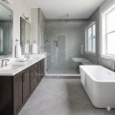 Płytka gresowa, podłogowa imitująca kamień w szarym kolorze, wykończenie powierzchni matowe, Pamesa Lavagna Pietra Di Argento Matt 30x60 położona na podłodze w łazience gdzie znajduje się prysznic, duża wanna oraz ciemne szafki