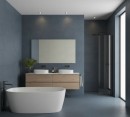 Elegancka, nowoczesna łazienka wykończona wielkoformatowymi gresami Marazzi Resin Avio 120x120 cm MQP8 o głębokim, szaroniebieskim kolorze z subtelną teksturą betonu, na tle ciemnych, matowych ścian i podłogi wyróżnia się biała wolnostojąca wanna