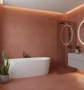 Nowoczesna łazienka wykończona matowymi płytkami Marazzi Resin Rosso Mattone 120x120 cm MQP5 w kolorze ceglastej czerwieni na ścianach i podłodze, wnętrze wyposażono w białą wolnostojącą wannę, szarą szafkę podumywalkową oraz okrągłe podświetlane lustra