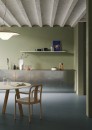 Nowoczesna kuchnia z niebieskimi płytkami podłogowymi Marazzi Resin Azzurro 60x120 cm oraz oliwkowymi ścianami, aranżację dopełniają metalowe szafki, surowy betonowy sufit oraz drewniane meble jadalniane
