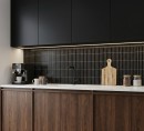 Mozaika DUNIN KitKat Black Matt 29,3x29,7. Nowoczesna czarna mozaika typu finger tiles do kuchni. Matowe, pionowe paski tworzą efektowny backsplash, który elegancko kontrastuje z drewnem i jasnym blatem, nadając wnętrzu architektonicznej głębi.