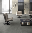 Nowoczesne wnętrze hotelu z jasnymi fotelami, stolikiem i szarymi płytkami podłogowymi imitującymi kamień Caesar Portraits Wells